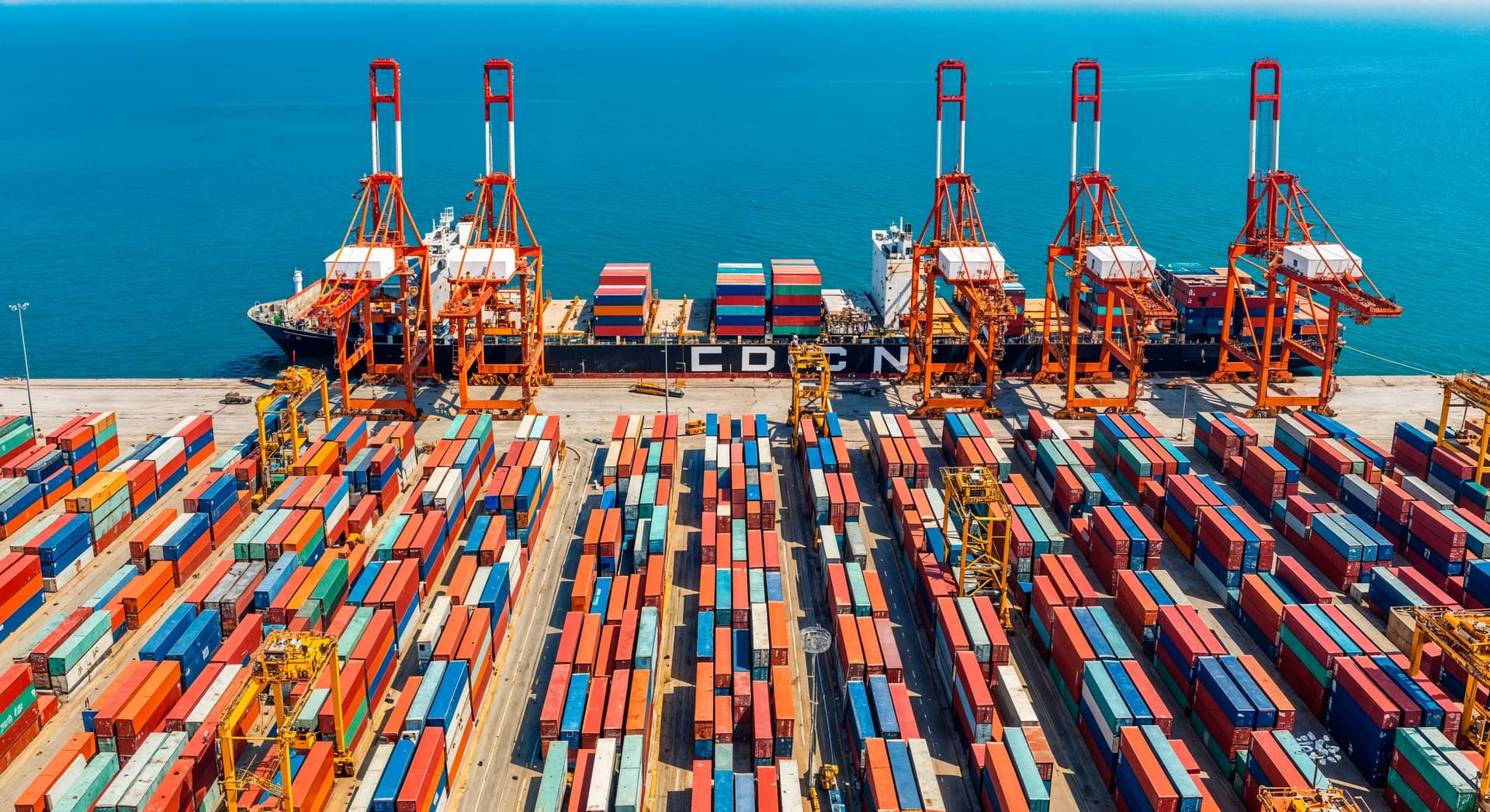 Container terminal with cranes loading a cargo ship